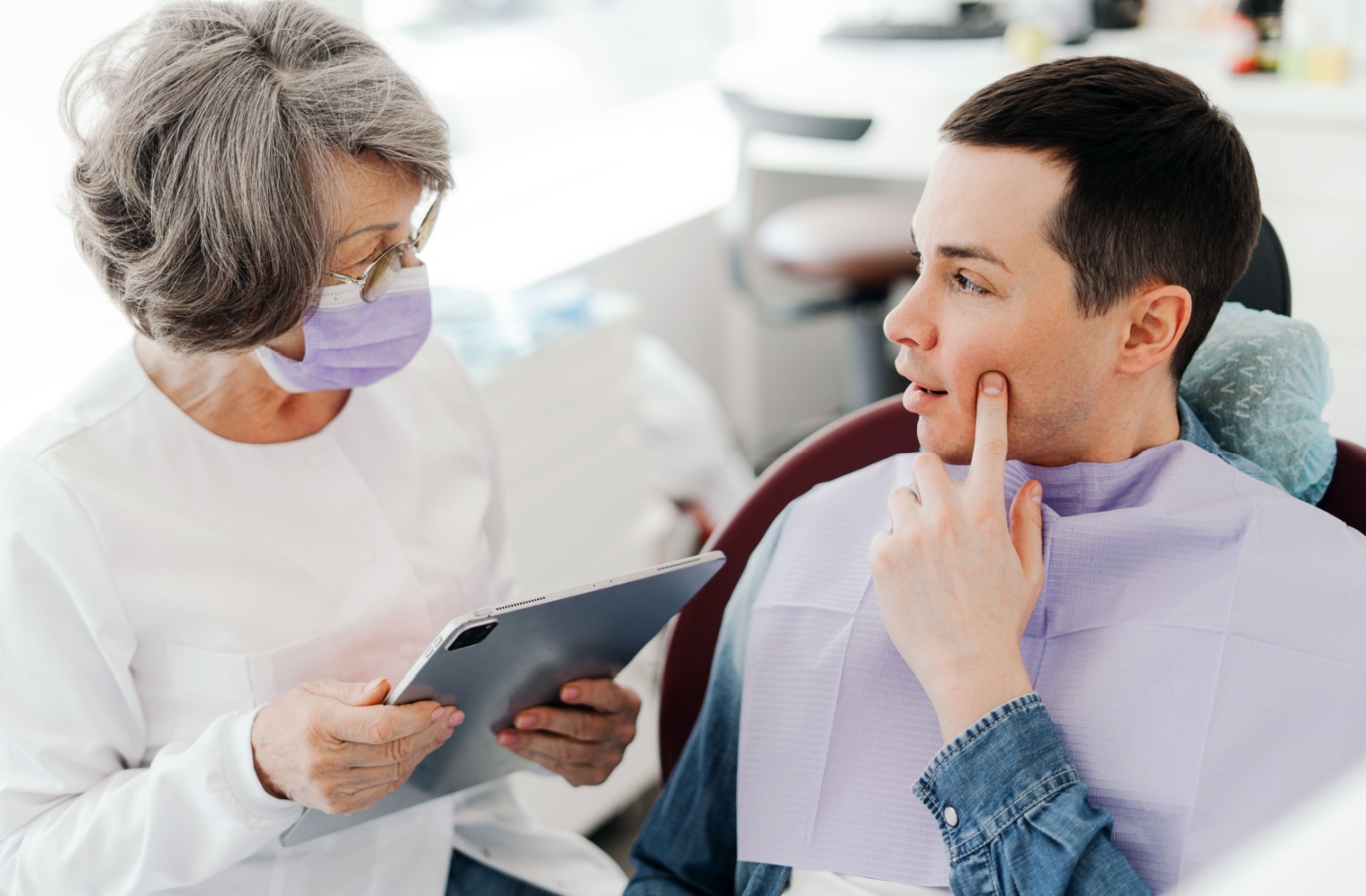 A dentist and patient discuss caring for teeth during a dental exam.