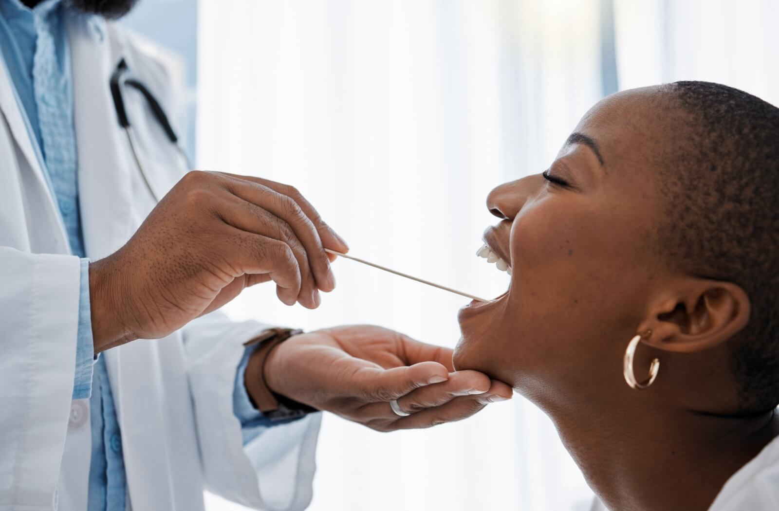 Someone gets an oral cancer screening from their dentist, showing that it's a simple and easy process.