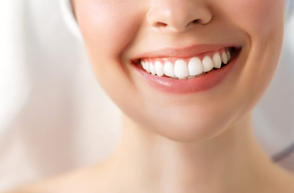 
A close-up of a person's lower face smiling to reveal straight, white teeth.